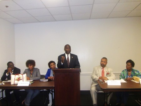 Amb. Jeremiah Sulunteh speaks at the conference. Those seated behind him include Members of the U.S. Congress