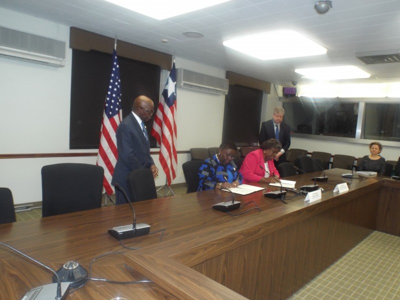 The Signing: Minister Kamara signs with Assistant Secretary Greenfield